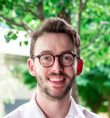 Larry smiling. Larry is a white man in his
late twenties, with short brown hair, a slightly patchy beard and round glasses.